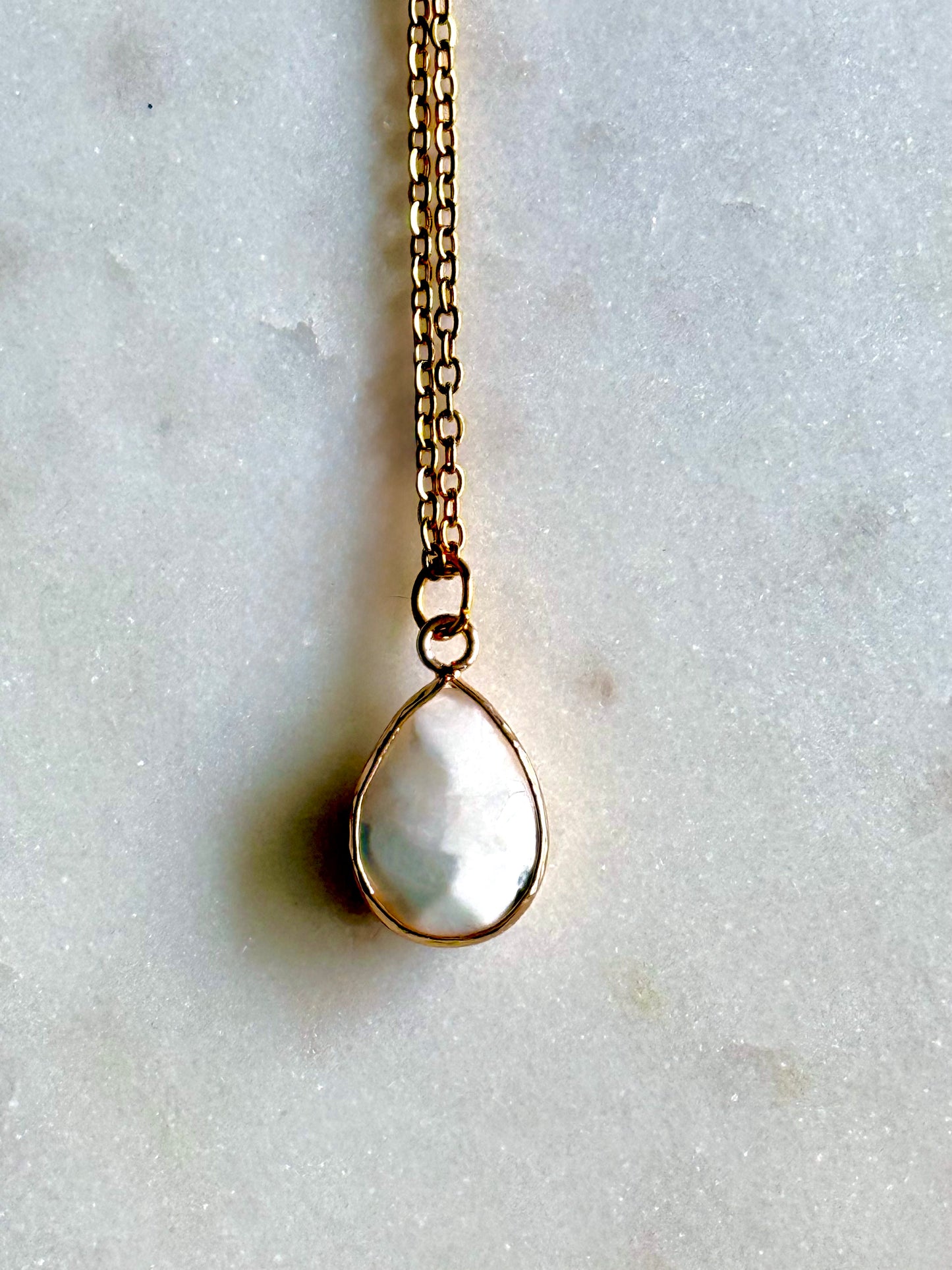 Necklace with a teardrop-shaped pendant on a light gray background