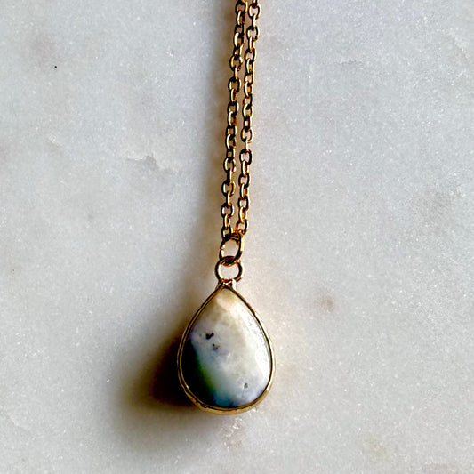 Necklace with a teardrop-shaped pendant on a light gray background
