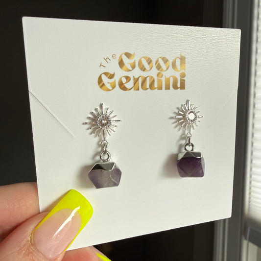 Pair of silver earrings with geometric designs on a card with 'GEMINI' text.